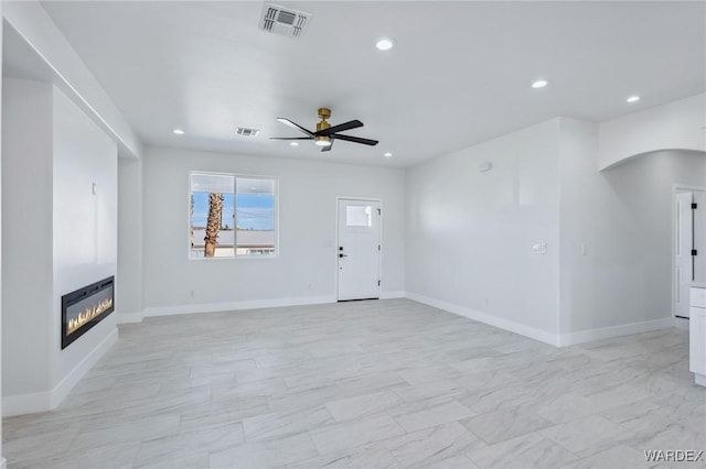 unfurnished living room with a ceiling fan, a glass covered fireplace, visible vents, and recessed lighting