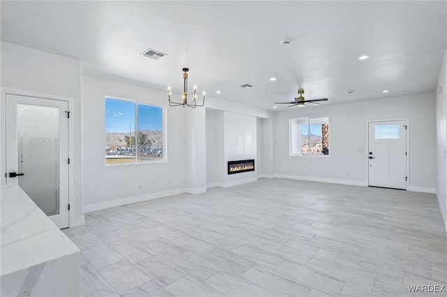 living area featuring recessed lighting, visible vents, a glass covered fireplace, baseboards, and ceiling fan with notable chandelier