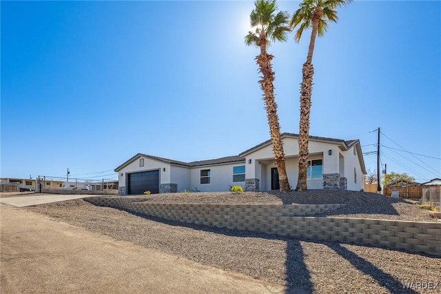 view of front of property with stone siding, concrete driveway, an attached garage, and stucco siding