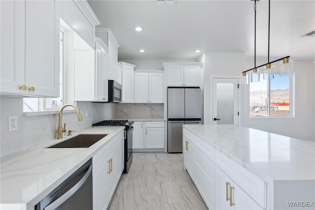 kitchen featuring stainless steel appliances, a sink, white cabinets, marble finish floor, and backsplash