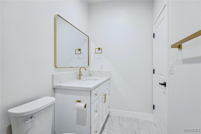 half bathroom with toilet, marble finish floor, baseboards, and vanity