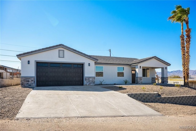 view of front of property featuring stone siding, an attached garage, driveway, and stucco siding