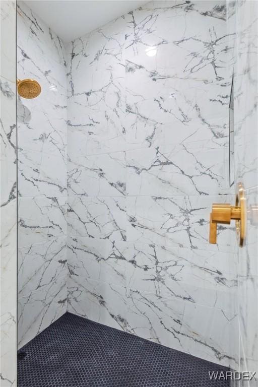 room details featuring a marble finish shower