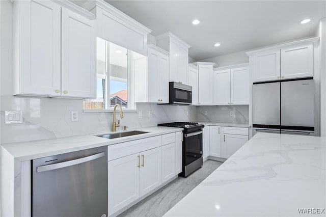 kitchen with marble finish floor, white cabinetry, stainless steel appliances, and a sink