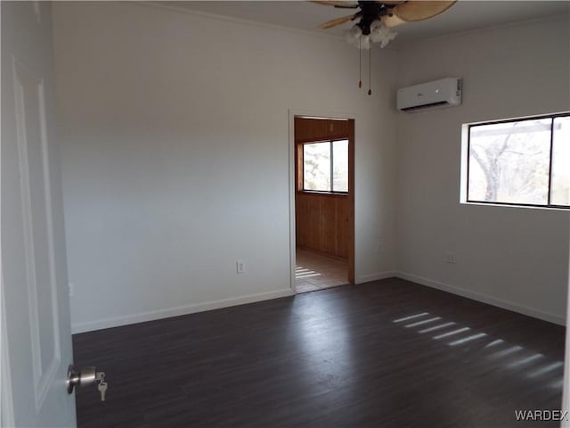 17516 N Ladera Dr, Dolan Springs, AZ 86441 - spare room with ceiling fan, baseboards, a wall unit AC, ornamental molding, and dark wood-style flooring
