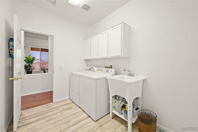 laundry room with visible vents, baseboards, light wood-type flooring, independent washer and dryer, and cabinet space