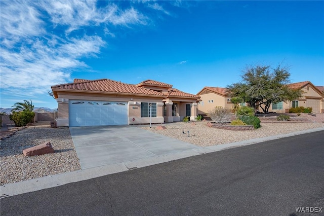 mediterranean / spanish home featuring an attached garage, driveway, a tile roof, and stucco siding