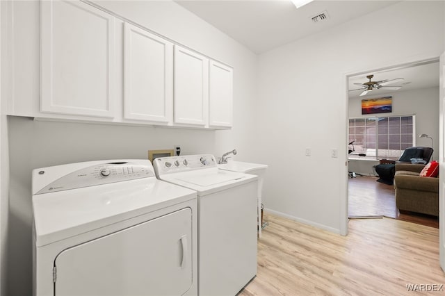 laundry area with visible vents, a ceiling fan, washer and dryer, light wood-type flooring, and cabinet space