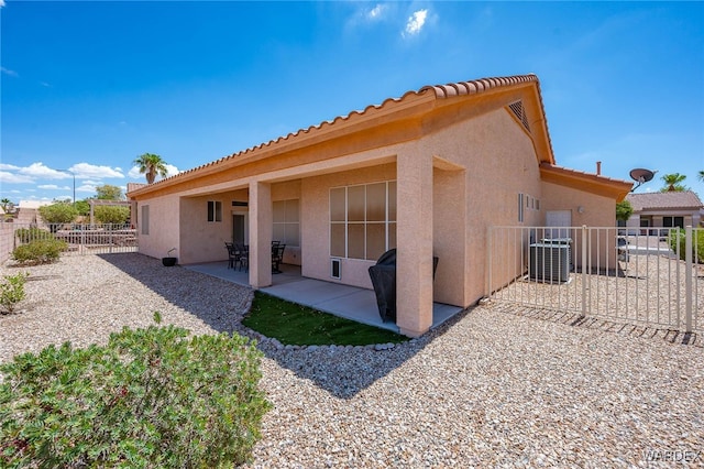 back of property featuring central air condition unit, a patio area, fence, and stucco siding