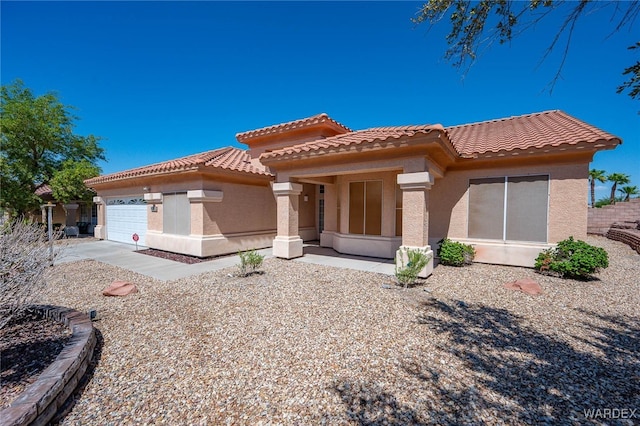 mediterranean / spanish-style house featuring a garage, a tiled roof, and stucco siding