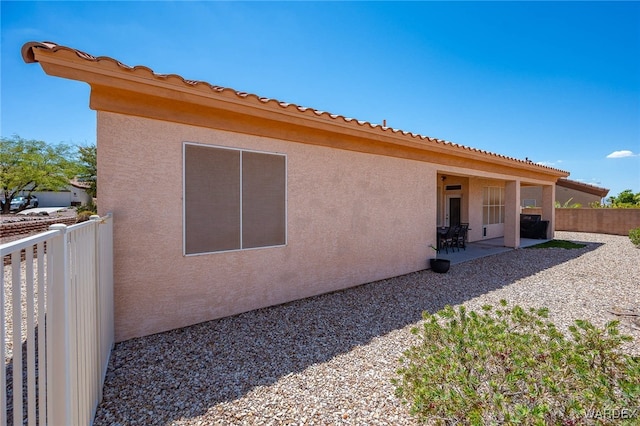 back of house featuring a patio area, fence, and stucco siding