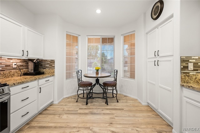 dining room featuring light wood finished floors, recessed lighting, and baseboards