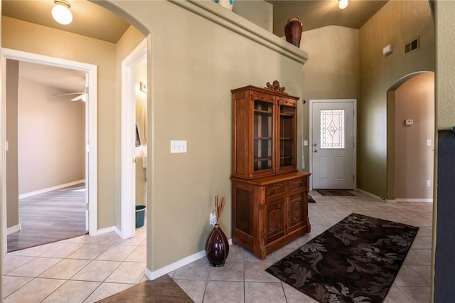 4875 N Famoso Dr, Kingman, AZ 86409 - entryway with arched walkways, light tile patterned flooring, a ceiling fan, a high ceiling, and baseboards