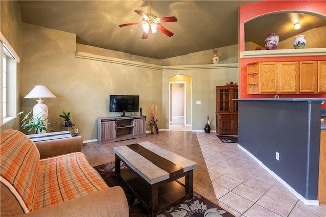 4875 N Famoso Dr, Kingman, AZ 86409 - living room featuring arched walkways, ceiling fan, light tile patterned floors, lofted ceiling, and baseboards