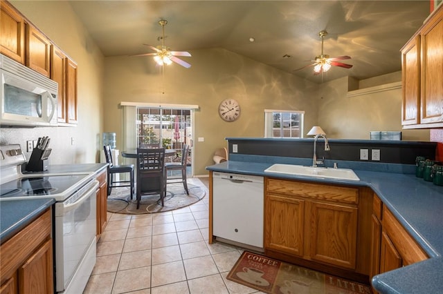4875 N Famoso Dr, Kingman, AZ 86409 - kitchen featuring white appliances, ceiling fan, a sink, brown cabinetry, and a peninsula