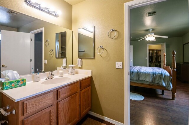 4875 N Famoso Dr, Kingman, AZ 86409 - bathroom featuring hardwood / wood-style flooring, ceiling fan, ensuite bathroom, vanity, and a textured wall