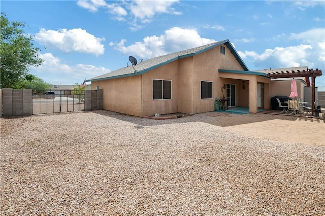 4875 N Famoso Dr, Kingman, AZ 86409 - back of property with a gate, fence, stucco siding, a patio, and a pergola