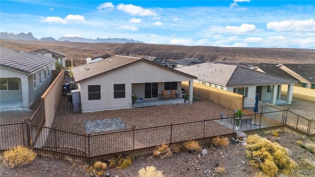 rear view of property with a patio, a fenced backyard, a mountain view, a residential view, and stucco siding