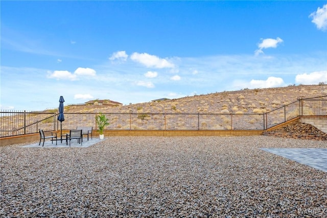 view of yard with a patio area, fence, and a mountain view