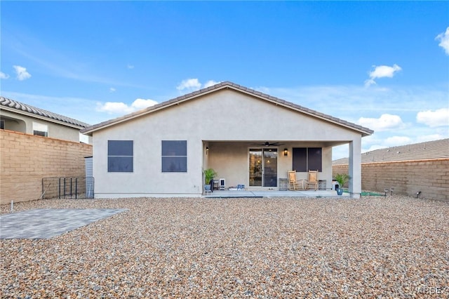 back of house featuring a patio, a fenced backyard, a ceiling fan, and stucco siding