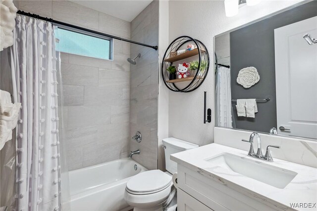 full bathroom with toilet, a textured wall, shower / bath combo with shower curtain, and vanity