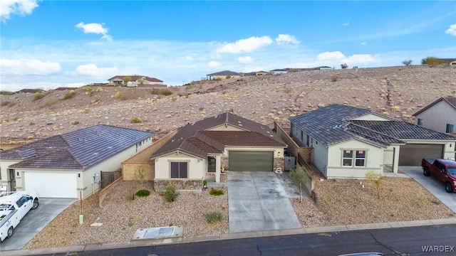 ranch-style house with a tile roof, stucco siding, concrete driveway, a garage, and stone siding