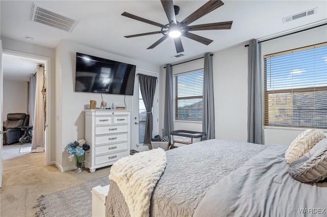 bedroom featuring light carpet, visible vents, and a ceiling fan