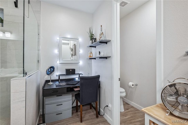 office area featuring light wood finished floors, visible vents, and baseboards