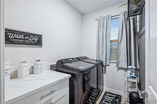 clothes washing area with independent washer and dryer, wood finished floors, and baseboards