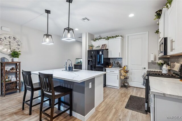 kitchen featuring white cabinets, pendant lighting, stainless steel appliances, and a sink