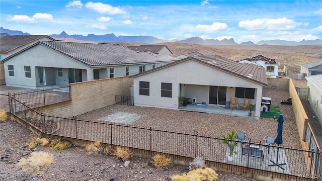 back of property featuring a fenced backyard, a mountain view, a residential view, stucco siding, and a patio area