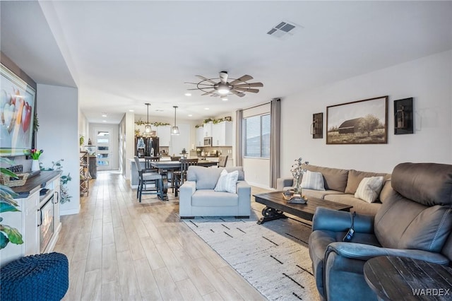 living area featuring recessed lighting, visible vents, a ceiling fan, light wood-type flooring, and baseboards