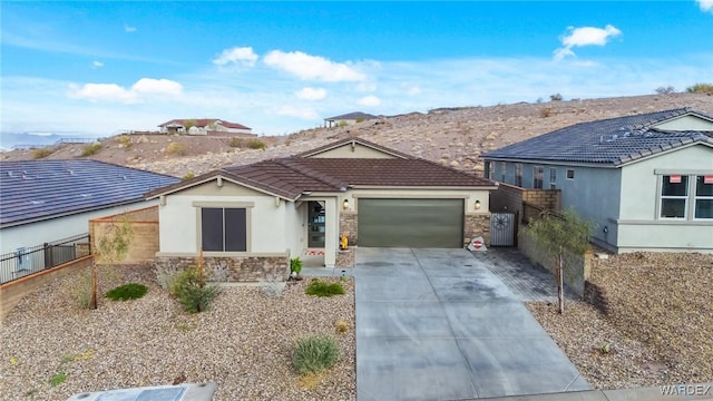 ranch-style house featuring a garage, concrete driveway, stone siding, a tiled roof, and stucco siding