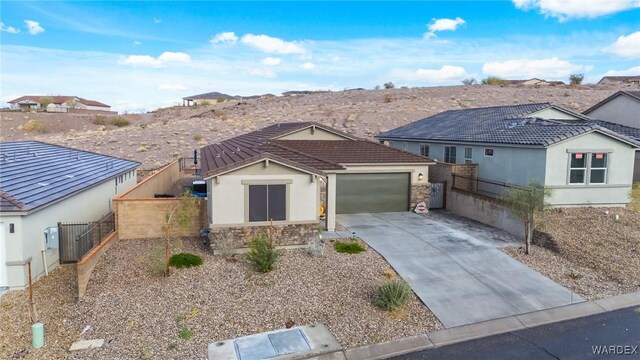 ranch-style home with stone siding, stucco siding, concrete driveway, and a tiled roof