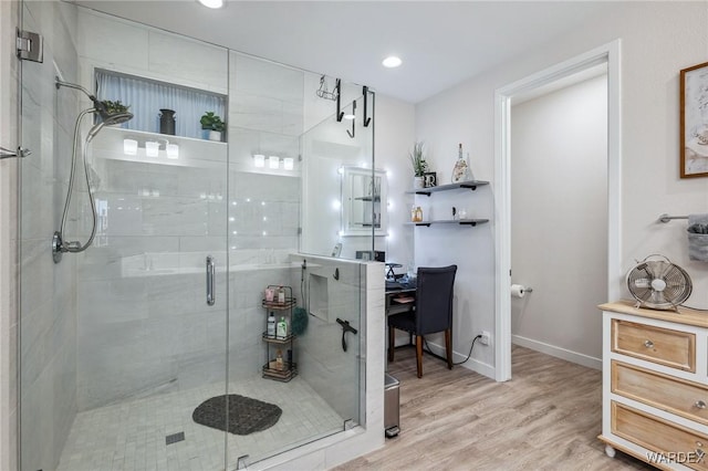 bathroom with a shower stall, baseboards, wood finished floors, and recessed lighting