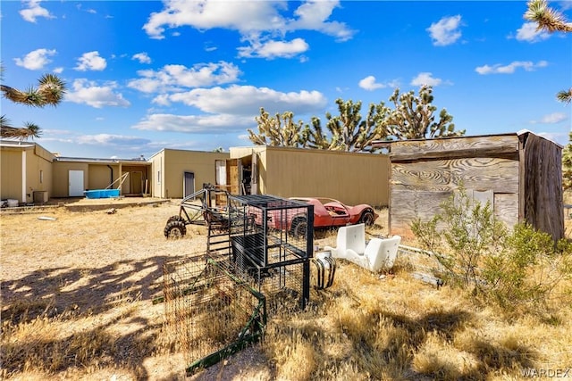 rear view of house with an outbuilding and central AC unit