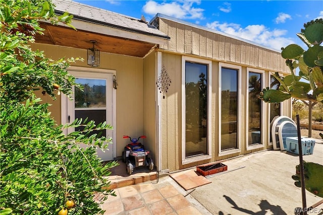 view of exterior entry featuring a patio area