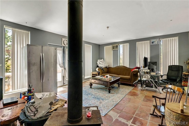 living area with stone tile flooring and a wood stove