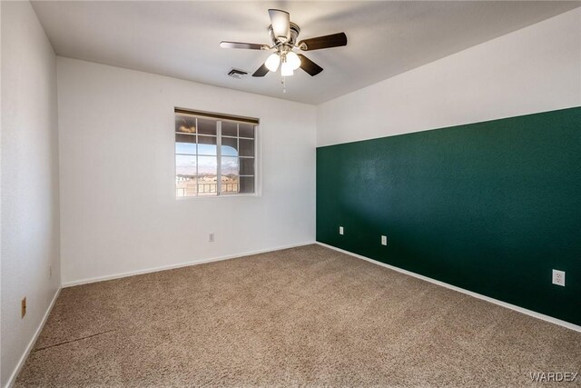 spare room featuring a ceiling fan, baseboards, visible vents, and carpet flooring