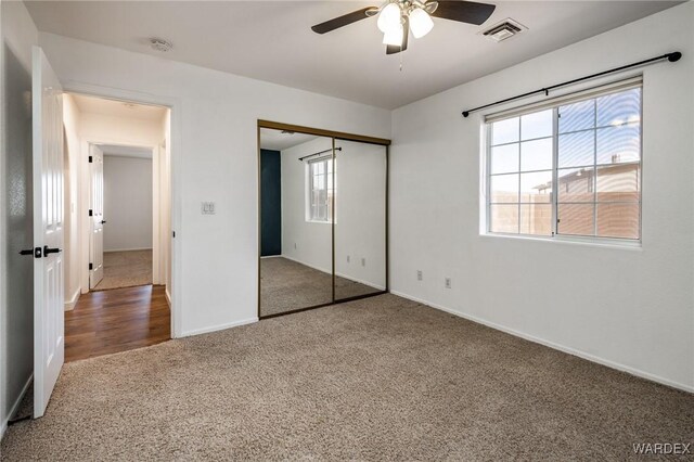 unfurnished bedroom featuring baseboards, visible vents, ceiling fan, carpet flooring, and a closet