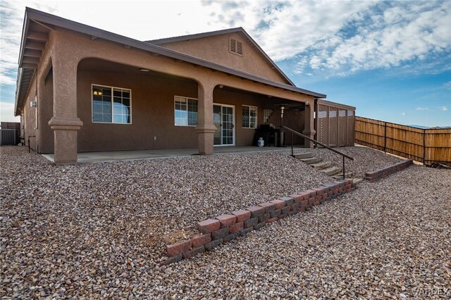 back of property with a patio area, fence, and stucco siding