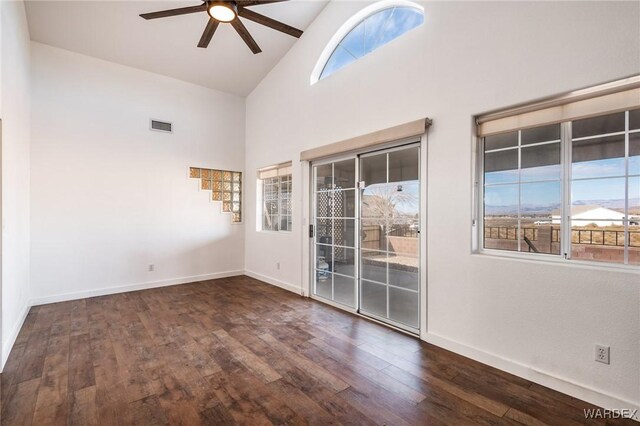 empty room with ceiling fan, dark wood-style flooring, visible vents, and baseboards