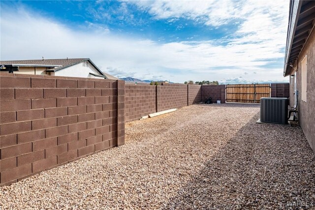 view of yard with central AC and a fenced backyard