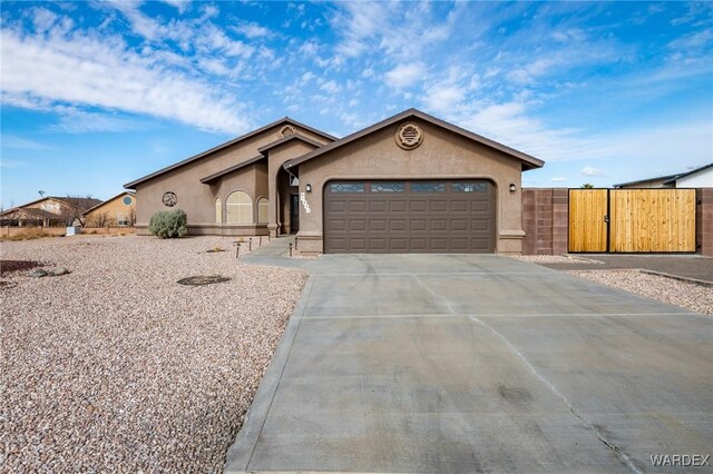 view of front of property featuring driveway, an attached garage, and stucco siding