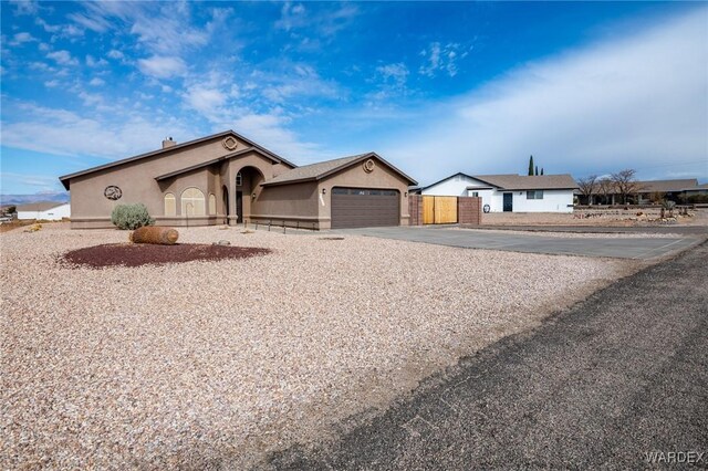 view of front of house featuring a garage, concrete driveway, and stucco siding