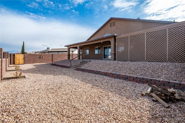 back of house with a patio area, a fenced backyard, and stucco siding