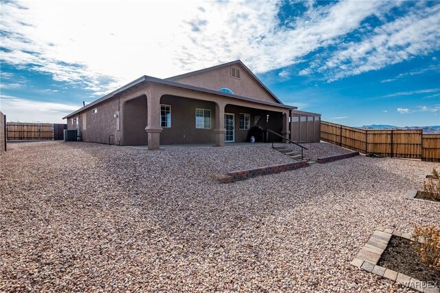 back of property featuring a fenced backyard, a patio, central AC, and stucco siding