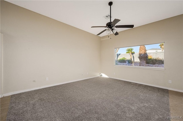 spare room featuring lofted ceiling, a ceiling fan, visible vents, baseboards, and dark colored carpet