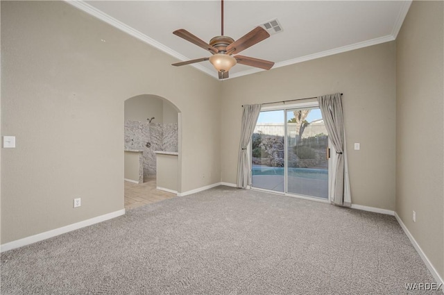 empty room with baseboards, visible vents, arched walkways, light colored carpet, and crown molding