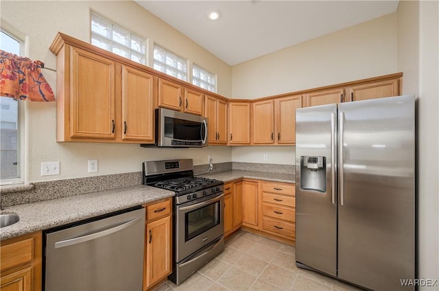 kitchen with appliances with stainless steel finishes, light stone counters, and recessed lighting